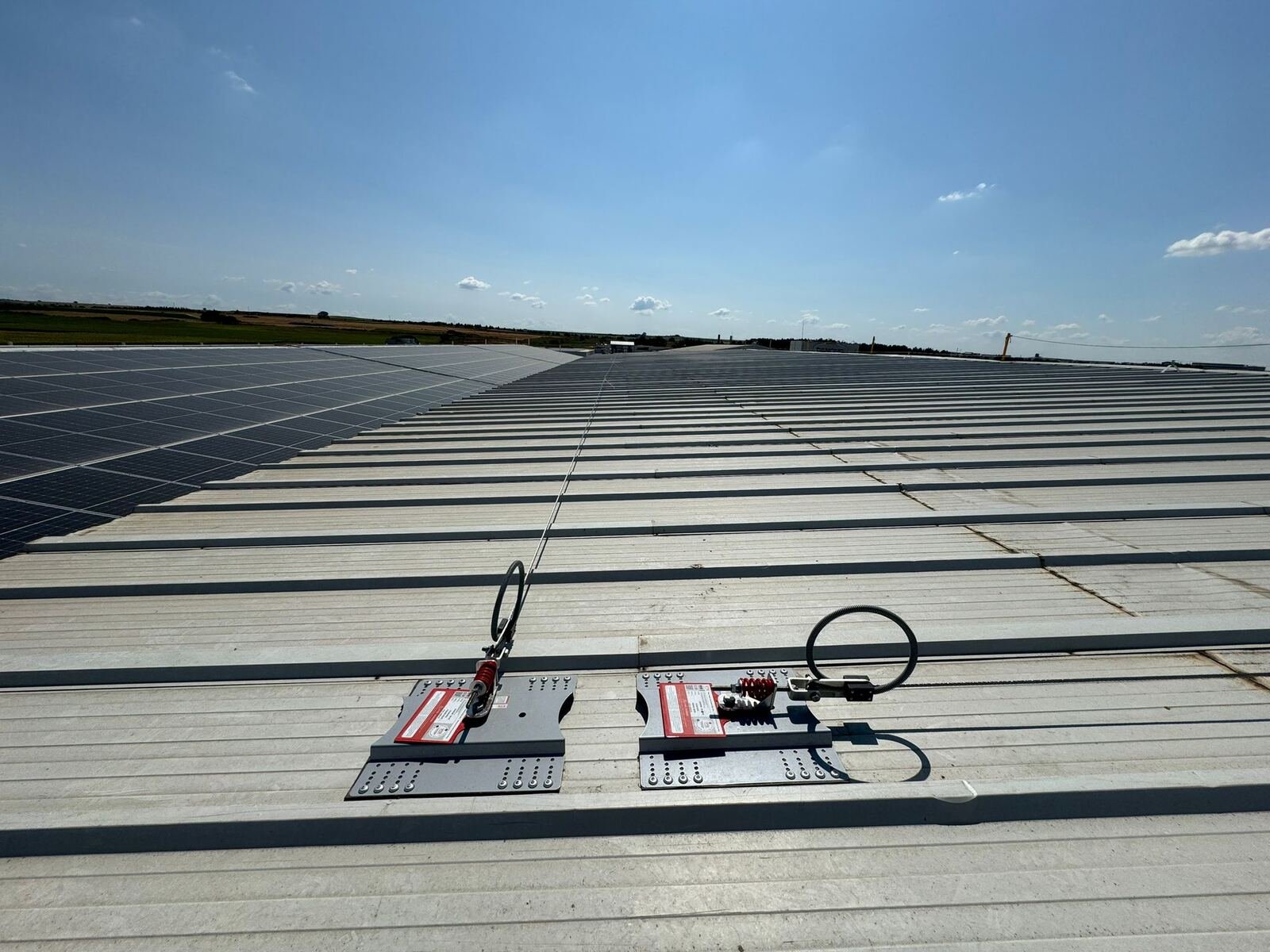 Línea de vida horizontal de cable instalada sobre techo con paneles solares - Divertical